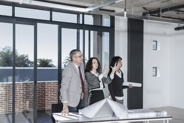 Businesspeople standing and talking in new open office - ZEF007538