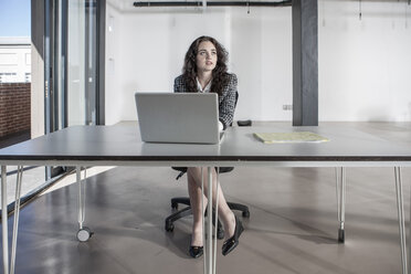 Businesswoman sitting at desk using laptop - ZEF007559