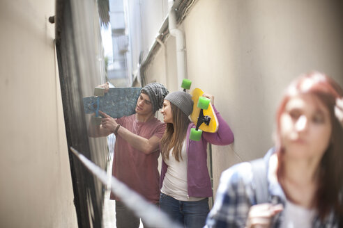 Friends with skateboards in a passageway - ZEF007578