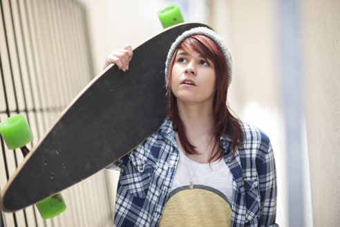 Young woman holding skateboard outdoors - ZEF007585