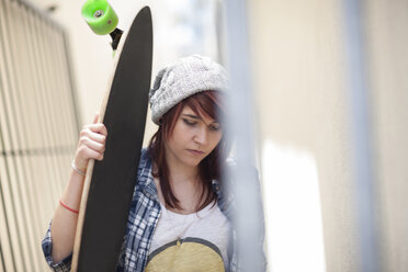 Junge Frau hält Skateboard im Freien - ZEF007586