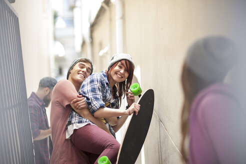 Friends with skateboard having fun in a passageway - ZEF007590