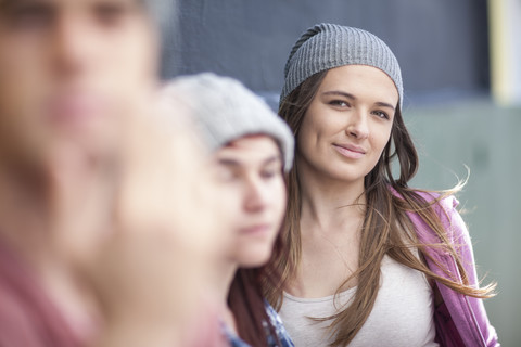 Portrait of young woman with friends outdoors stock photo