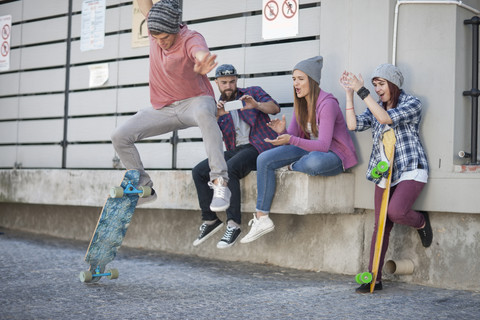 Young man with friends doing a skateboard trick stock photo