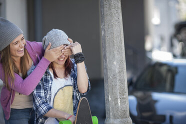 Zwei verspielte Freundinnen mit Skateboard - ZEF007608