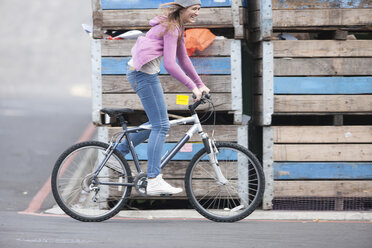 Happy teenage girl riding bicycle - ZEF007620