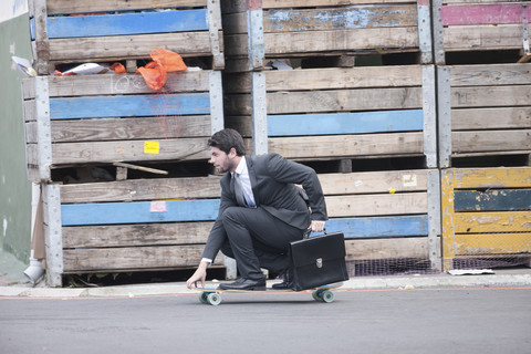 Businessman riding on skateboard stock photo