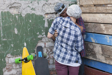 Junges Paar mit Skateboard umarmend und küssend - ZEF007629