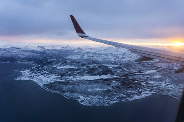 Airplane's wing over the mountains, from the window, while flying, sunrise - LOMF000121