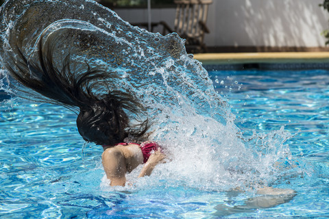 Frau im Schwimmbadwasser mit Haare ziehen, lizenzfreies Stockfoto