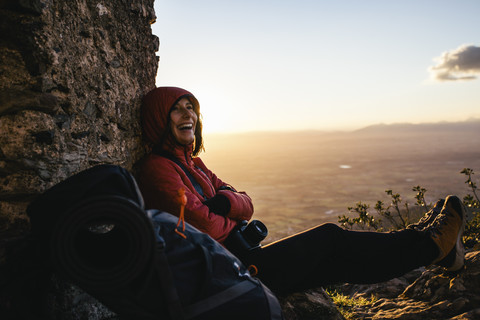 Spain, Catalunya, Girona, happy female hiker resting at stone structure stock photo