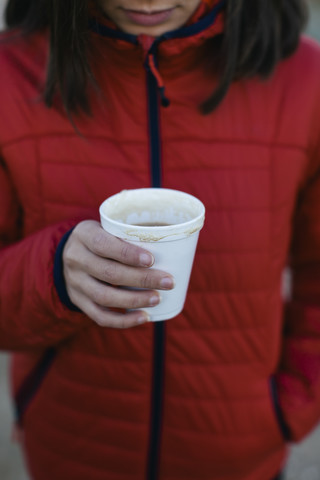 Frau hält Tasse mit heißem Getränk, lizenzfreies Stockfoto