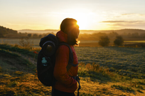 Spain, Catalunya, Girona, female hiker on field at sunrise - EBSF001178