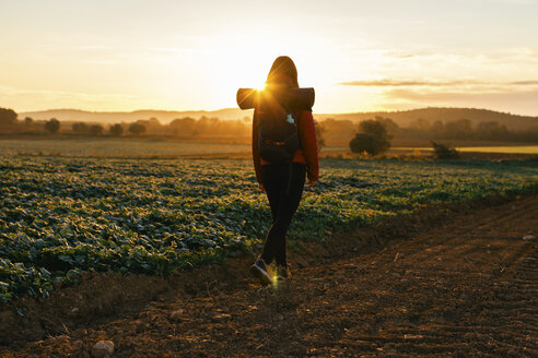 Spanien, Katalonien, Girona, Frau wandert auf Feldweg bei Sonnenaufgang - EBSF001179