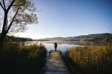 Spain, Catalunya, Girona, female hiker on jetty at a lake enjoying the nature - EBSF001184