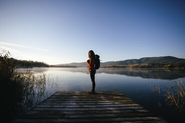 Spain, Catalunya, Girona, female hiker on jetty at a lake enjoying the nature - EBSF001185