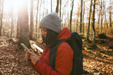 Spanien, Katalonien, Girona, Wanderin im Wald schaut auf Handy - EBSF001198