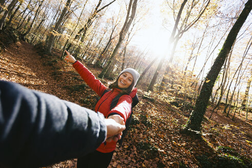 Spain, Catalunya, Girona, smiling woman in the woods holding man's hand - EBSF001204