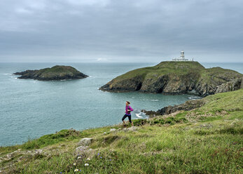 UK, Pembrokeshire, Strumble Head, Ältere Frau läuft den Küstenpfad - ALRF000274