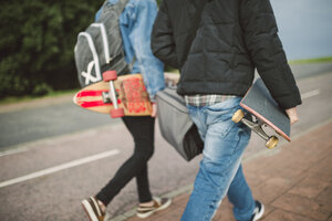 Rückenansicht von zwei gehenden Skatern mit Longboard und Skateboard - RAEF000723