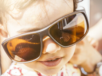 Portrait of little girl wearing oversized sunglasses - KRPF001683