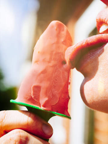 Woman eating homemade strawberry ice cream, close-up stock photo