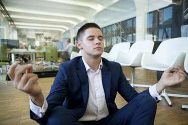 Young businessman meditating in office - WESTF021605