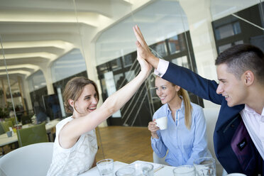Happy businessman and businesswoman high fiving - WESTF021613