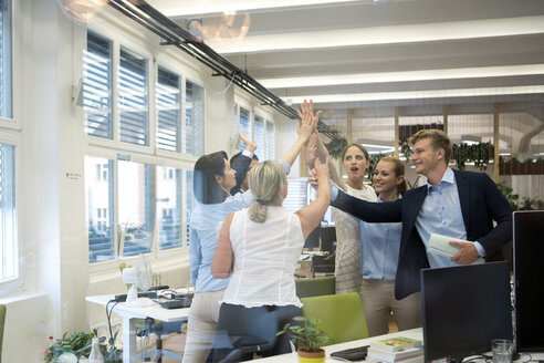 Successful business team high fiving in office - WESTF021623