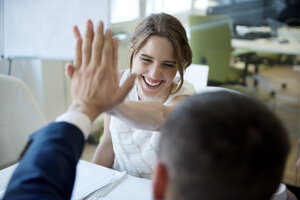 Happy businesswoman and businessman high fiving - WESTF021641