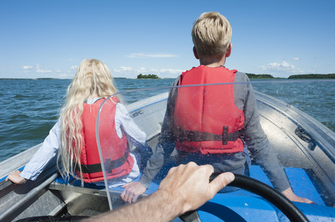 Finnland, Schären von Turku, Houtskaer, Vater und seine beiden Kinder fahren im Motorboot, lizenzfreies Stockfoto