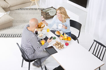 Ehepaar am Frühstückstisch mit Smartphones - MAEF011068