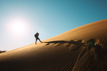 Namibia, Namib Desert, Sossusvlei, Man taking pictures on a dune at sunset - GEMF000551