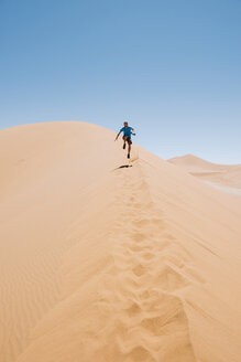 Namibia, Namib Desert, Sossusvlei, Man running down a dune - GEMF000553