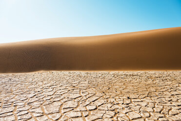 Namibia, Namib-Wüste, Sossusvlei, Trockene rissige Erde, Düne und blauer Himmel - GEMF000563