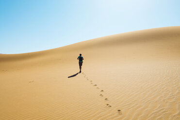 Namibia, Namib Desert, Sossusvlei, Man walking through the dunes - GEMF000564