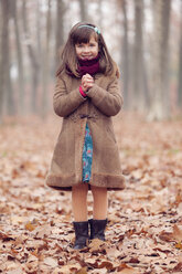 Young girl, brown coat in park, autum, smiling, hands folded - XCF000045