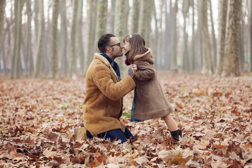 Father kissing his daughter in park, autumn - XCF000050