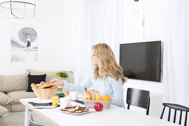 Blonde Frau beim Frühstück am gedeckten Tisch für zwei Personen - MAEF011127