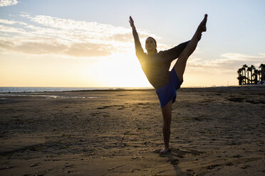 Spanien, Puerto Real, Silhouette einer jungen Frau beim Yoga am Strand bei Sonnenuntergang - KIJF000048