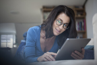 Woman at home using digital tablet - RBF003658