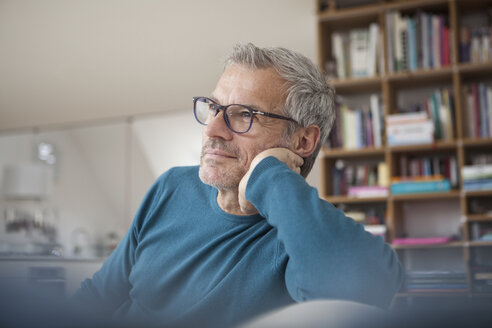 Entspannter Mann zu Hause auf der Couch sitzend - RBF003689