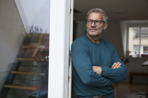 Mature man leaning against balcony door - RBF003711