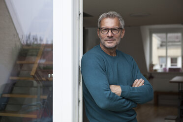 Portrait of mature man leaning against balcony door - RBF003712