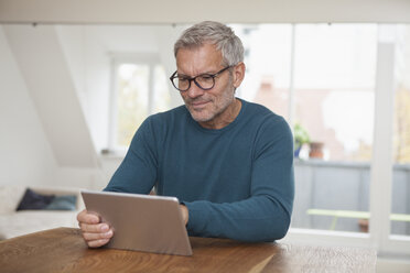 Älterer Mann zu Hause mit digitalem Tablet - RBF003718