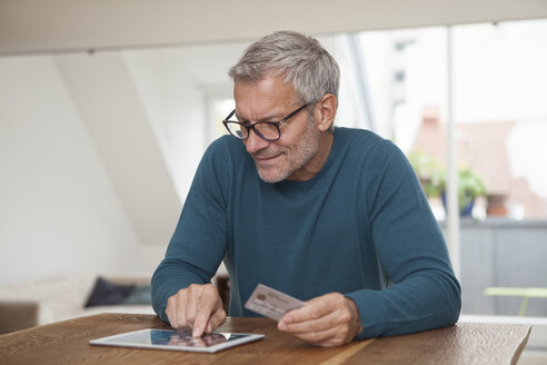 Reifer Mann beim Online-Shopping zu Hause - RBF003719