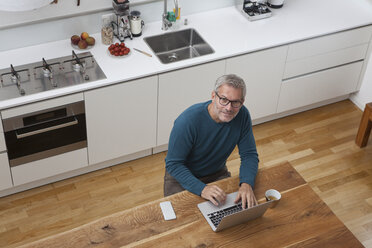 Älterer Mann in der Küche mit Laptop - RBF003723