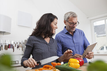 Älteres Paar mit digitalem Tablet beim Kochen in der Küche - RBF003726