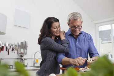 Mature couple preparing vegetables in kitchen - RBF003730