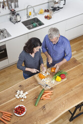 Älteres Paar bereitet Gemüse in der Küche zu - RBF003732